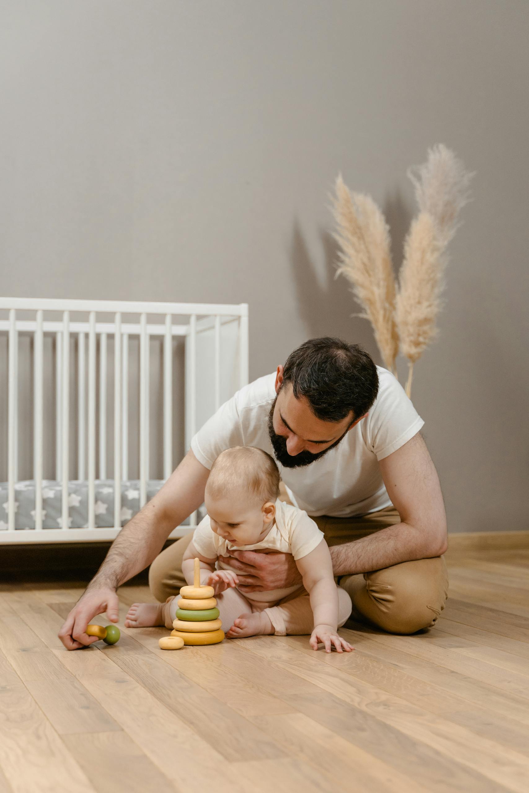 Father playing with baby wondering about sleep training