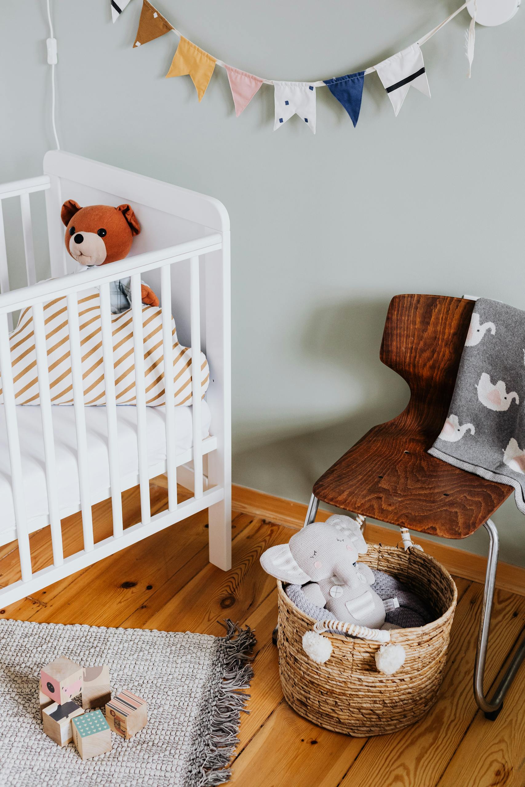 Cozy nursery interior with crib, chair, and plush toys, perfect for a baby's comfort.