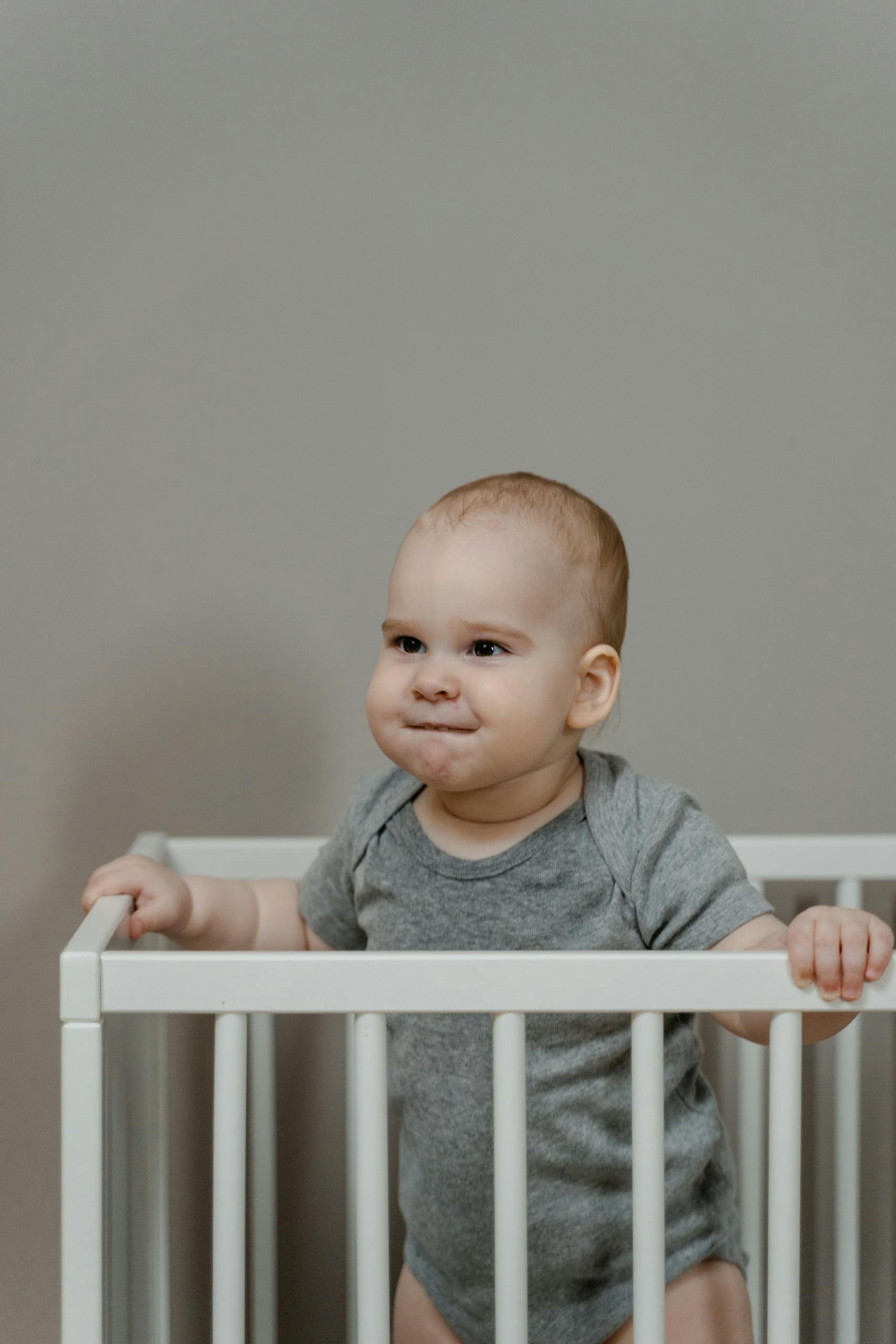 Cute baby in a crib not taking a nap.